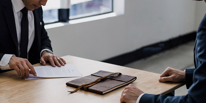 People reviewing paperwork across a desk